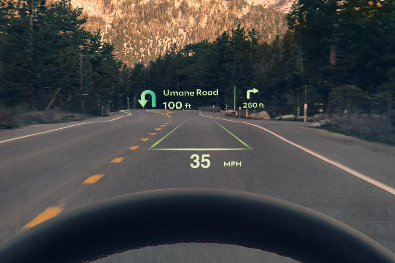 Head-up display shows navigation info on a road through mountains. Instructions are for a U-turn in 100 ft and right turn in 250 ft. Speed is 35 MPH.